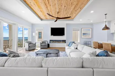 a living room with a white couch and a tv at Emerald View in Inlet Beach