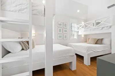 a white bedroom with two beds and a bunk room at Good Vibrations in Santa Rosa Beach