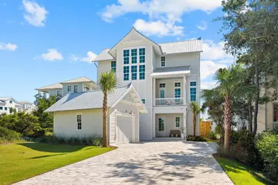 a white house with palm trees in the driveway at Good Vibrations in Santa Rosa Beach