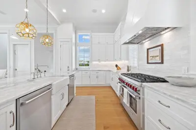 a kitchen with white cabinets and a stove top oven at Good Vibrations in Santa Rosa Beach