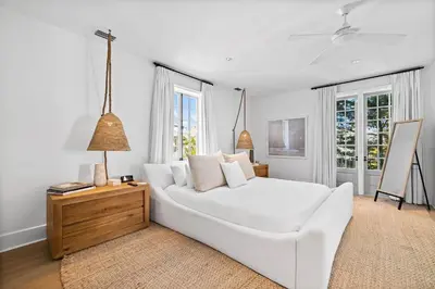 a white living room with a white couch and windows at Playa Blanca in Rosemary Beach