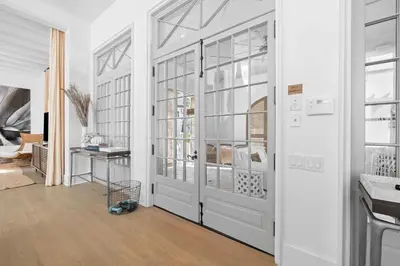 a white hallway with a door and windows at Playa Blanca in Rosemary Beach