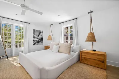 a white bedroom with a white bed and two windows at Playa Blanca in Rosemary Beach