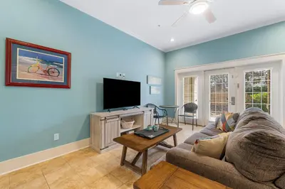 a living room with a couch and a flat screen tv at Beach Please Beach House by Panhandle Getaways in Panama City Beach