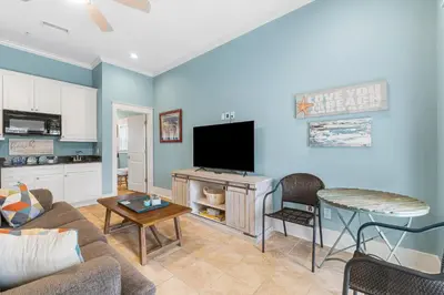 a living room with a couch and a flat screen tv at Beach Please Beach House by Panhandle Getaways in Panama City Beach