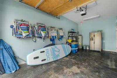a room with a surfboard hanging on a wall at Beach Please Beach House by Panhandle Getaways in Panama City Beach