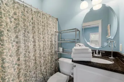 a bathroom with a sink and a toilet and a mirror at Beach Please Beach House by Panhandle Getaways in Panama City Beach