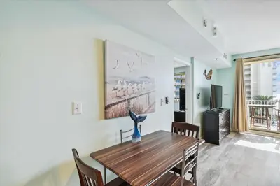 a dining room with a wooden table and chairs at Shores of Panama 415 condo in Panama City Beach