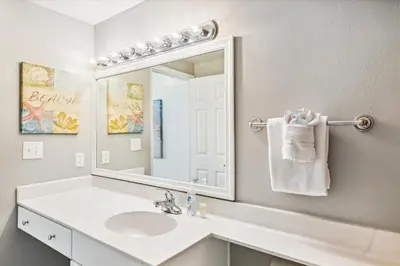 a white bathroom with a sink and a mirror at Shores of Panama 415 condo in Panama City Beach