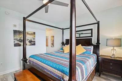 a bedroom with a four poster bed and a lamp at Shores of Panama 415 condo in Panama City Beach