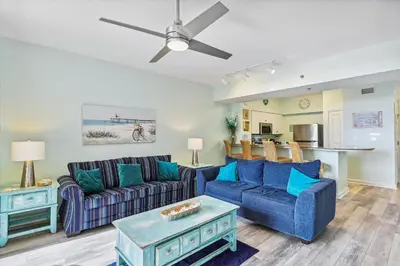 a living room with two couches and a table at Shores of Panama 415 condo in Panama City Beach