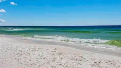 a sandy beach with the ocean in the background at Villas at Seagrove A101 - Sunshine Sabbatical in Santa Rosa Beach