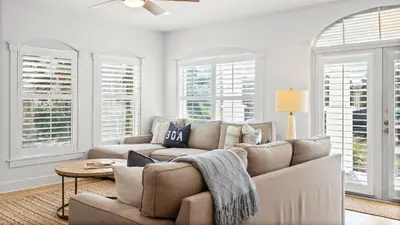 a living room with a couch and windows at Villas at Seagrove A101 - Sunshine Sabbatical in Santa Rosa Beach