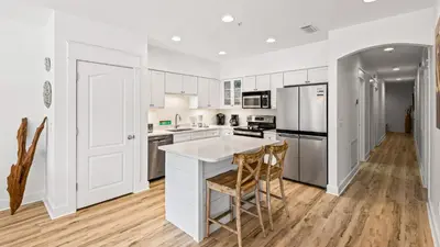 a kitchen with white cabinets and a white island at Villas at Seagrove A101 - Sunshine Sabbatical in Santa Rosa Beach