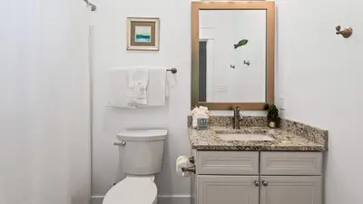 a bathroom with a toilet and a sink and a mirror at Villas at Seagrove A101 - Sunshine Sabbatical in Santa Rosa Beach