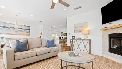 a living room with a couch and a fireplace at Villas at Seagrove A101 - Sunshine Sabbatical in Santa Rosa Beach