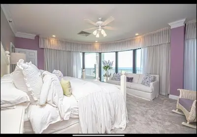 a bedroom with a white bed and a couch at Dancing Dolphins, Watercrest 1803,1804 in Panama City Beach