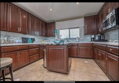 a large kitchen with wooden cabinets and a window at Dancing Dolphins, Watercrest 1803,1804 in Panama City Beach