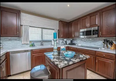 a kitchen with wooden cabinets and a granite counter top at Dancing Dolphins, Watercrest 1803,1804 in Panama City Beach