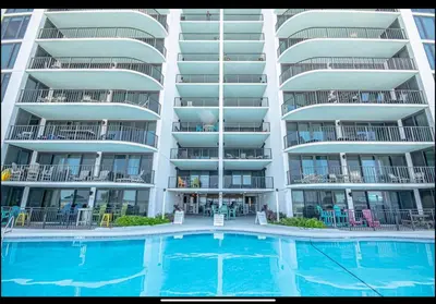 a large apartment building with a swimming pool in front of it at Dancing Dolphins, Watercrest 1803,1804 in Panama City Beach
