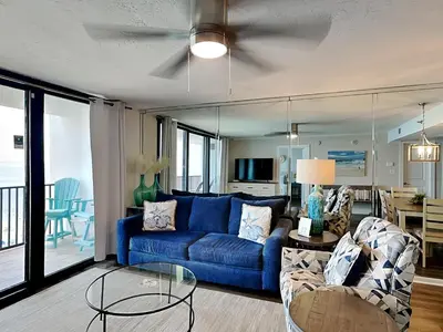 a living room with a blue couch and a table at One Seagrove Place #507 in Santa Rosa Beach