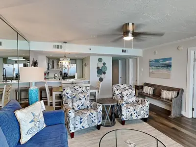 a living room with a blue couch and a kitchen at One Seagrove Place #507 in Santa Rosa Beach