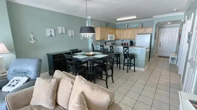 a living room and kitchen with a couch and a table at Tropic Winds 2007 in Panama City Beach