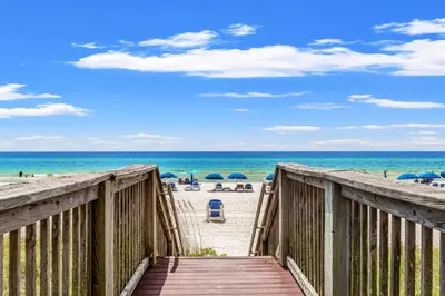 a boardwalk leading to the beach with umbrellas at Tropic Winds 2007 in Panama City Beach