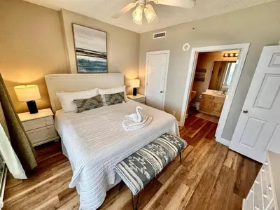 a bedroom with a large bed with a white comforter at Tropic Winds 1208 in Panama City Beach