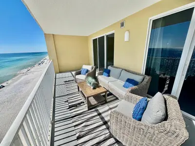 a balcony with a couch and chairs on the beach at Tropic Winds 1208 in Panama City Beach