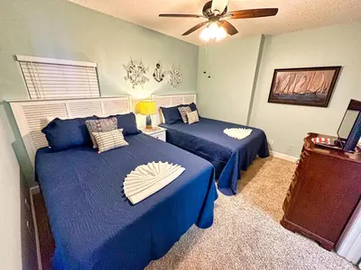 a bedroom with two beds and a ceiling fan at Tropic Winds 701 in Panama City Beach