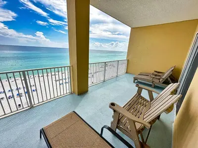 a balcony with two chairs and the ocean at Tropic Winds 701 in Panama City Beach