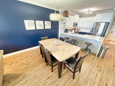 a kitchen and dining room with a table and chairs at Tropic Winds 2005 in Panama City Beach