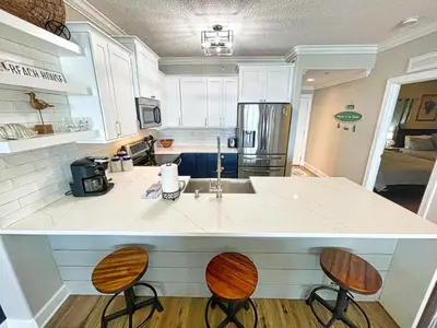 a kitchen with a counter and two stools at Tropic Winds 2005 in Panama City Beach