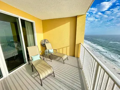 two chairs and a table on a balcony with the ocean at Tropic Winds 2005 in Panama City Beach