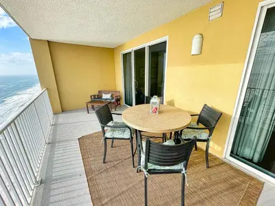 a table and chairs on a balcony with the ocean at Tropic Winds 2005 in Panama City Beach