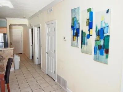 a hallway with three paintings on the wall at Tropic Winds 2105 in Panama City Beach