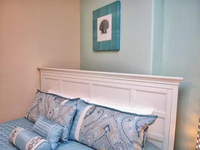 a bed with a headboard and two pillows at Tropic Winds 2105 in Panama City Beach