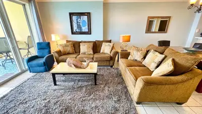 a living room with two couches and a table at Tropic Winds 2105 in Panama City Beach
