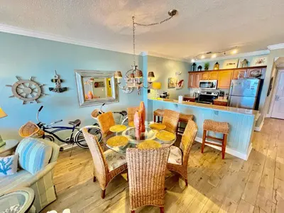 a kitchen and dining room with a table and chairs at Ocean Reef 1407 in Panama City Beach