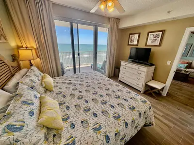 a bedroom with a bed and a view of the ocean at Ocean Reef 1407 in Panama City Beach
