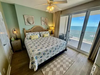a bedroom with a bed with a view of the ocean at Ocean Reef 1407 in Panama City Beach