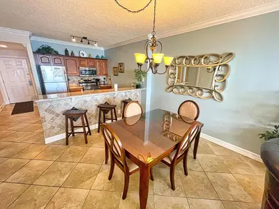 a dining room and kitchen with a table and chairs at Ocean Reef 1802 in Panama City Beach