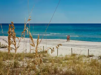 a couple of people walking on the beach at Ocean Reef 1802 in Panama City Beach