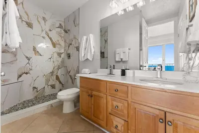 a bathroom with a sink and a toilet and a mirror at Ocean Reef 1904 in Panama City Beach