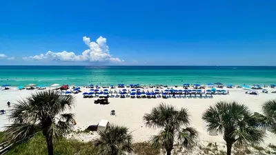 a beach with a lot of umbrellas and the ocean at Ocean Reef 1904 in Panama City Beach