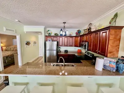 a kitchen with a sink and a refrigerator at Tropic Winds 1904 in Panama City Beach