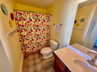 a bathroom with a shower curtain with a toilet and a sink at Tropic Winds 1904 in Panama City Beach