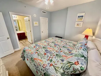 a bedroom with a bed with a colorful comforter at Tropic Winds 1904 in Panama City Beach