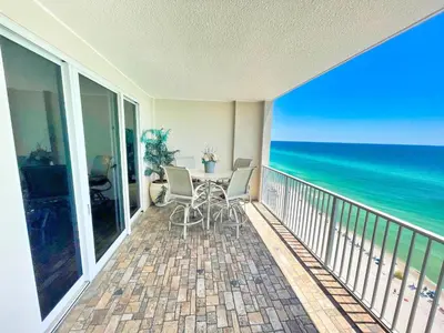 a balcony with a table and chairs and the ocean at Ocean Reef 1608 in Panama City Beach